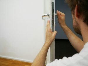serrurier Lille en train d’installer une serrure sur une porte blanche