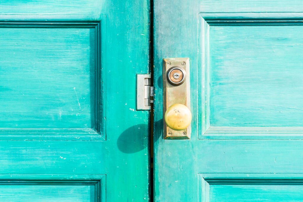 Porte d’entrée peinte en vert avec serrure à cylindre, typique des accès gérés par un serrurier pour copropriété.