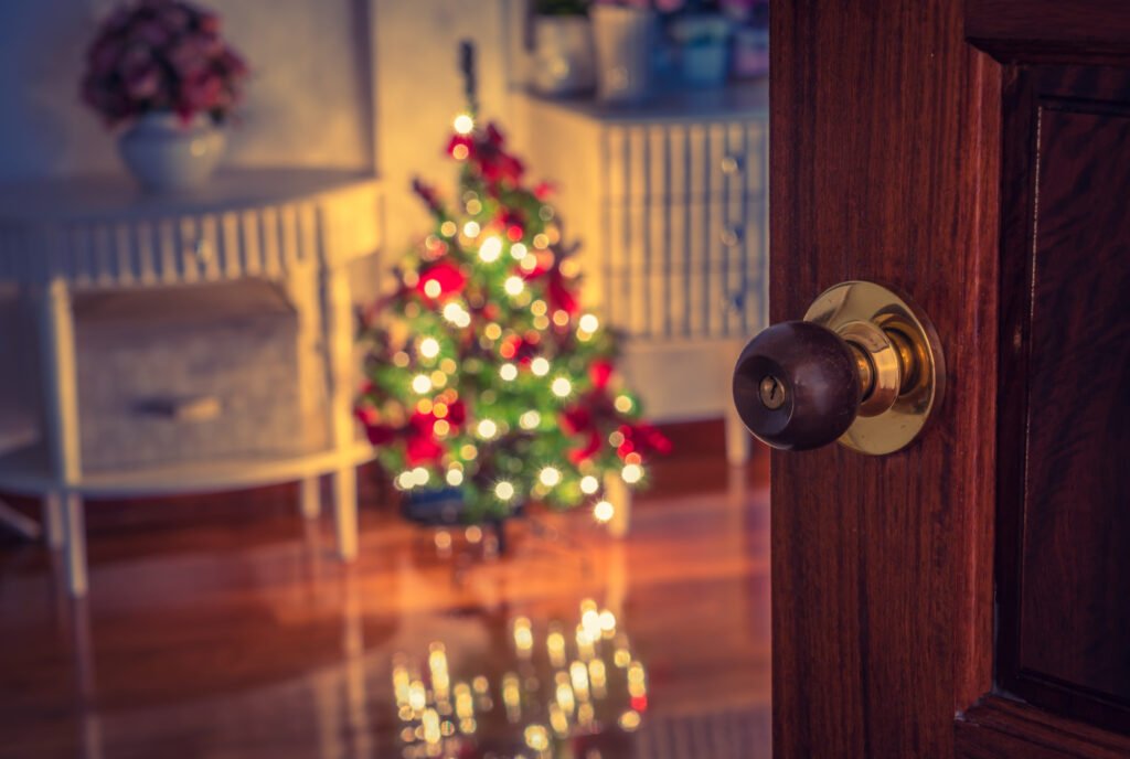 Intérieur de logement avec porte entrouverte et sapin de Noël, protégé par une serrure contrôlée par le serrurier pour copropriété.