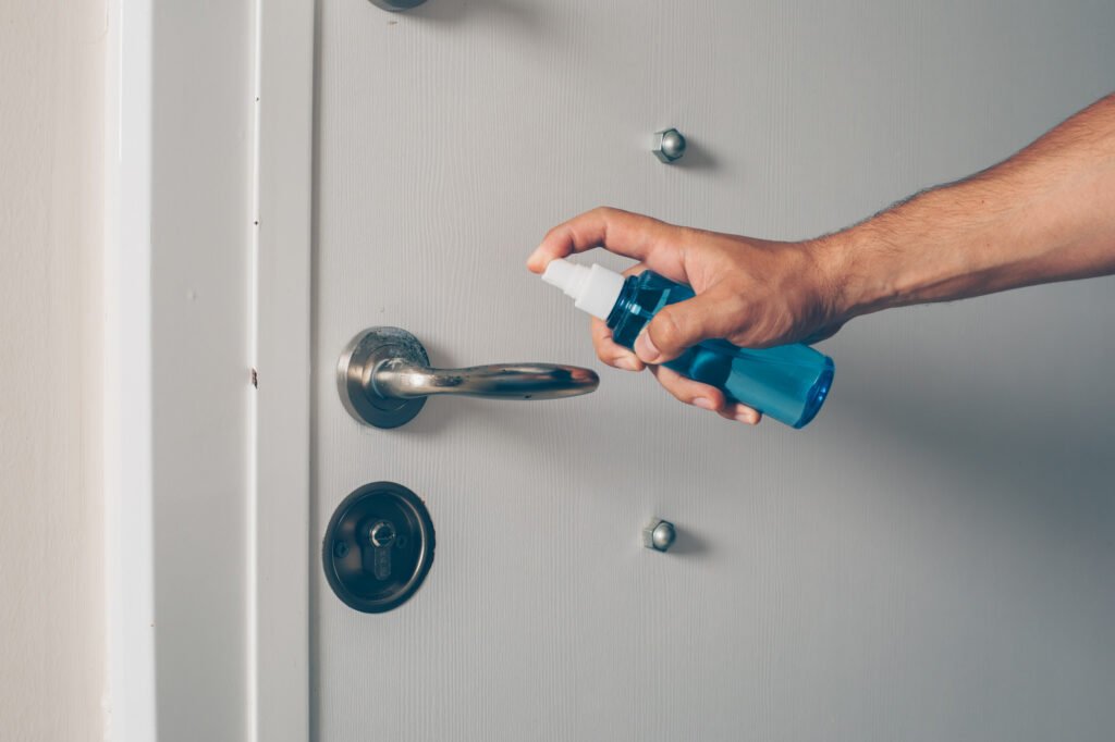 pulvérisation de lubrifiant lors d’un entretien cylindre de serrure sur une porte d’entrée.