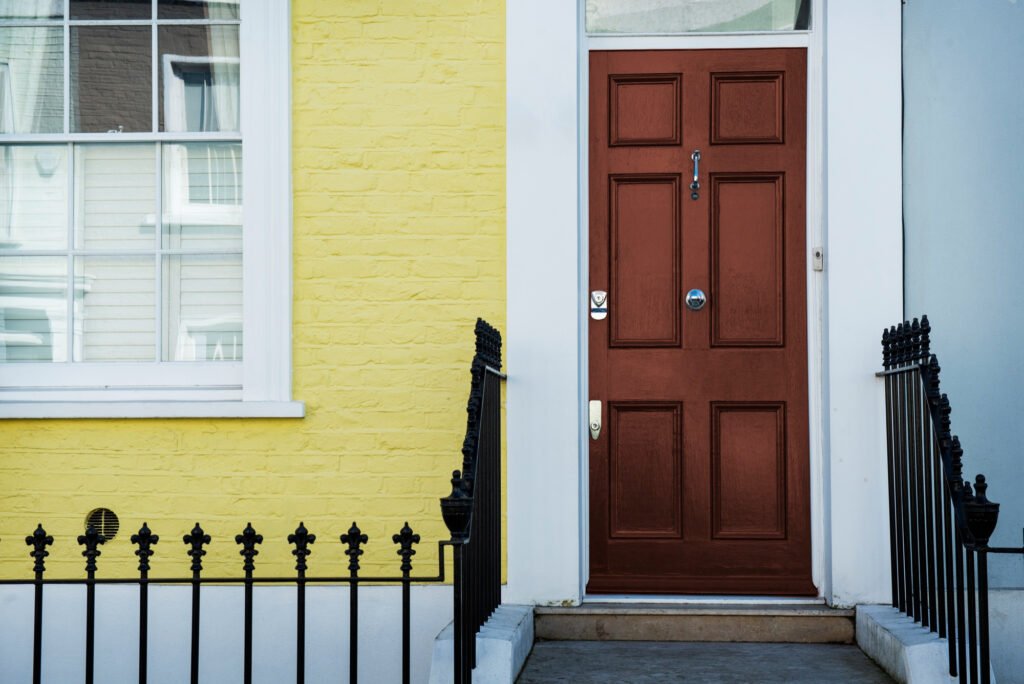 porte d’entrée fermée dans une façade jaune, typique d’une situation nécessitant une ouverture porte claquée sans clé.
