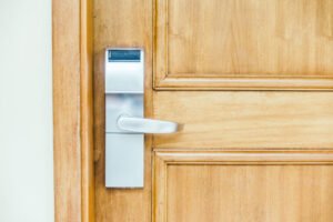 serrure électronique moderne sur porte en bois clair nécessitant un entretien serrure multipoints régulier.