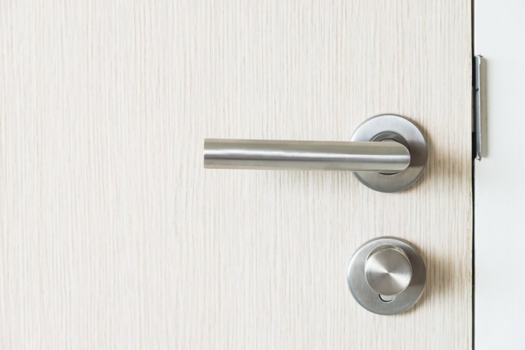 serrure cylindrique sur porte blanche, typique d’un mécanisme nécessitant un entretien serrure multipoints