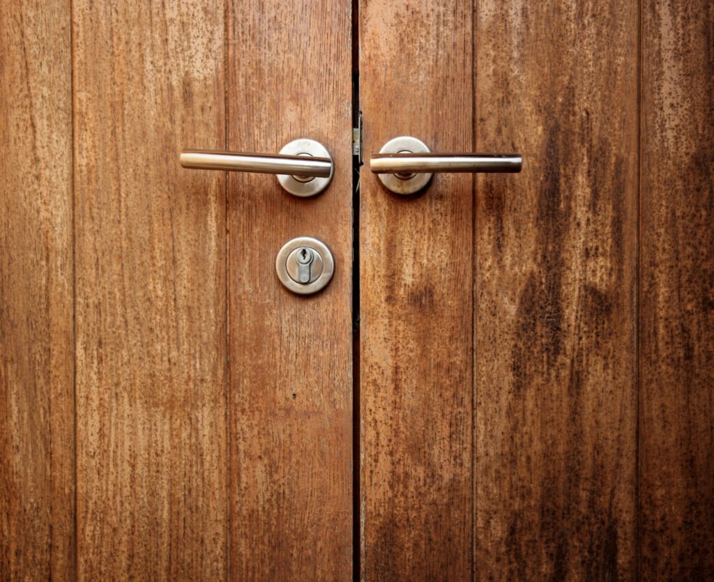 double porte en bois avec poignées alignées, équipée d’une serrure à points nécessitant un entretien serrure multipoints