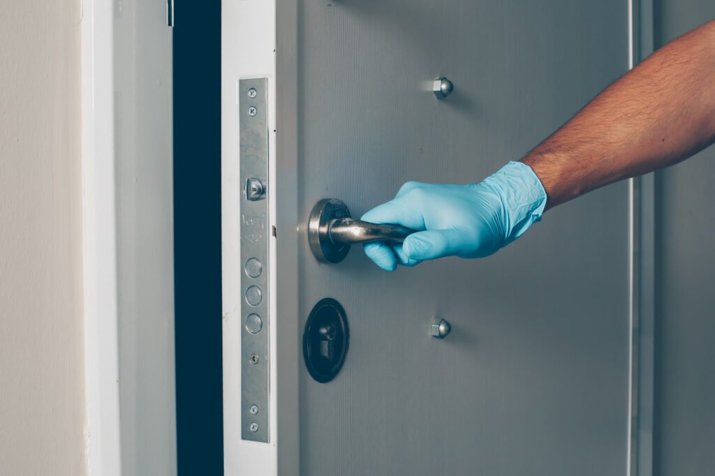 technicien avec gants de protection testant une serrure blindée lors d’un entretien serrure multipoints