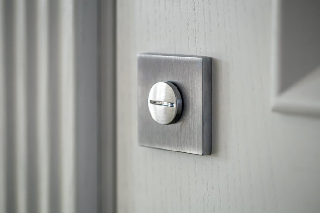 Verrou automatique porte entrée à bouton rotatif métallique sur porte d’intérieur moderne.