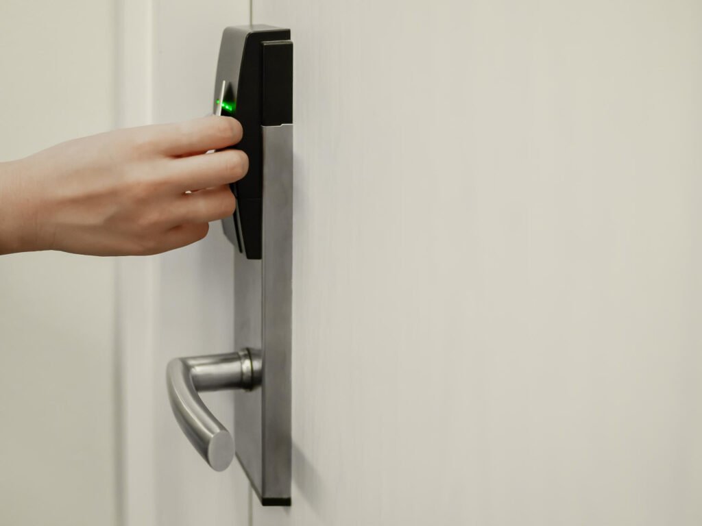 Main utilisant une carte d’accès sur un verrou automatique porte entrée à technologie RFID.