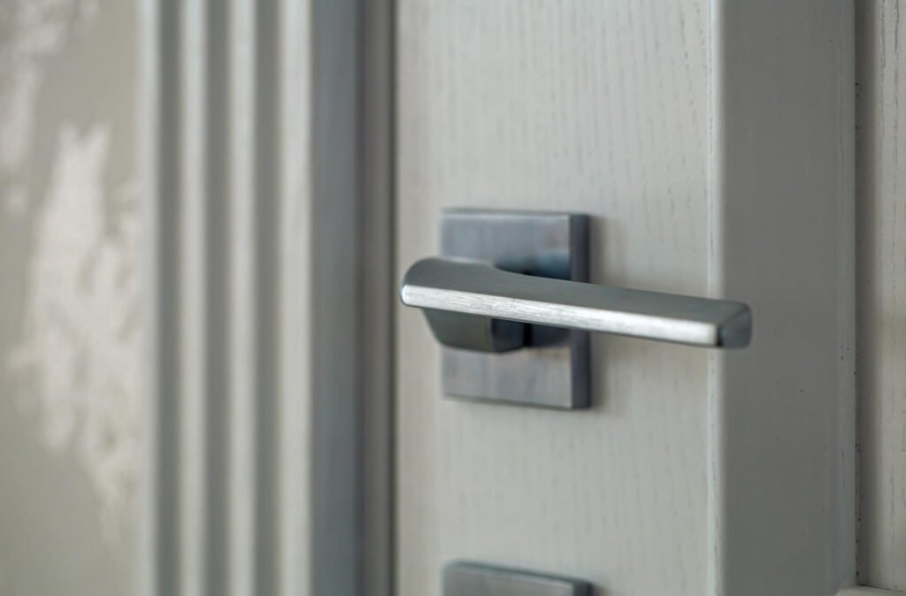 Bouton lumineux rouge d’activation sur un panneau relié à un verrou automatique porte entrée.
