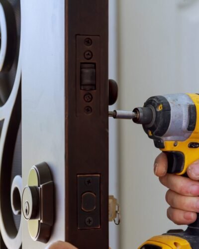 new-house-hand-close-up-builder-in-installing-a-door-lock-the-door-of-close-up--e1696401715498