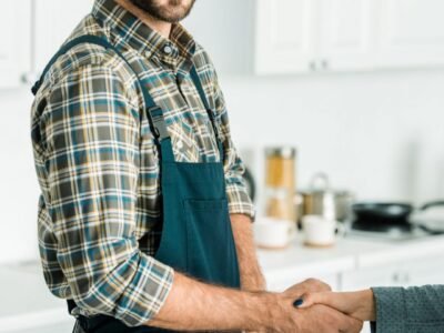 smiling-handsome-plumber-and-customer-shaking-hands-in-kitchen smiling-handsome-plumber-and-customer-shaking-hands-in-kitchen